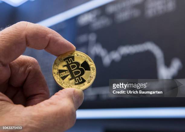 Symbol photo on the topics digital curreny, cryptocurrency, currency speculation, stock market, etc. The picture shows a Bitcoin in front of the...