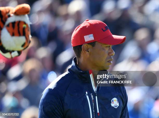 Golfer Tiger Woods reacts during his singles match with Europe's Spanish golfer Jon Rahm on the third day of the 42nd Ryder Cup at Le Golf National...