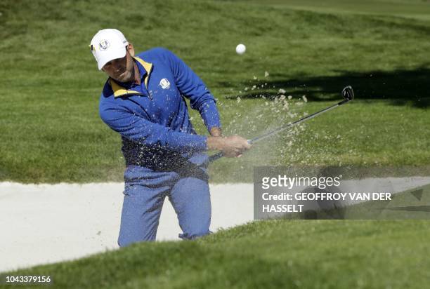 Europe's Spanish golfer Sergio Garcia plays a shot out of a bunker during his singles match with US golfer Rickie Fowler on the third day of the 42nd...