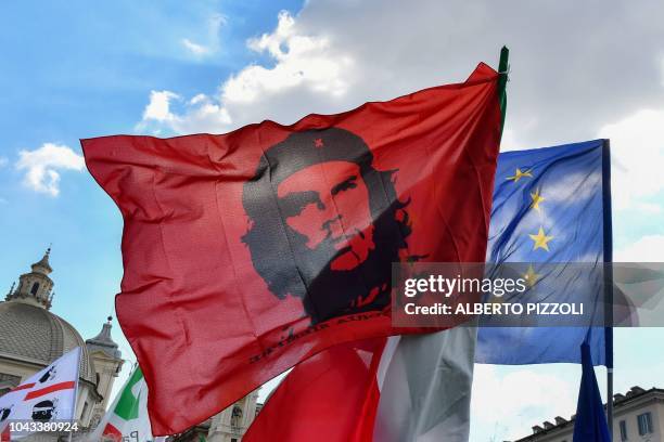 Supporters of Italy's centre-left Democratic Party wave a flag showing Argentine Marxist revolutionary, Ernesto Che Guevara, and a flag of the...