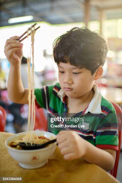 asia boy eating penang famous hokkien mee - hokkien mee stock pictures, royalty-free photos & images