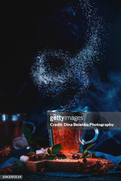 spiral of sugar above a double wall tea glass. action food photography. dynamic teatime on a dark background with copy space. - magic swirl stock pictures, royalty-free photos & images