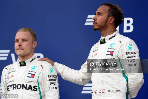 Race winner Lewis Hamilton of Great Britain and Mercedes GP and second placed Valtteri Bottas of Finland and Mercedes GP look on, on the podium...