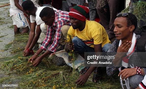 Irecha Oromo people soak grass and pray by the river during the