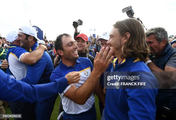 Europe's Italian golfer Francesco Molinari celebrates with Europe's English golfer Tommy Fleetwood after victory in during his singles match on the...