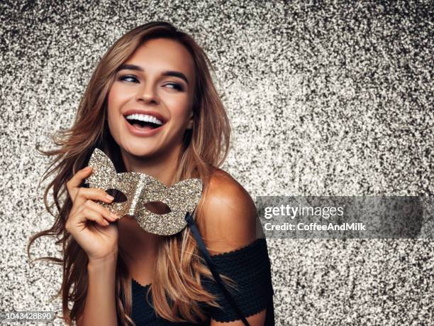 woman with mask standing in front of golden background - carnaval woman stock pictures, royalty-free photos & images