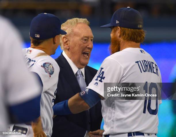 Manny Machado and Justin Turner of the Los Angeles Dodgers talks with retired broadcaster Vin Scully who was attending a pregame ceremony honoring...