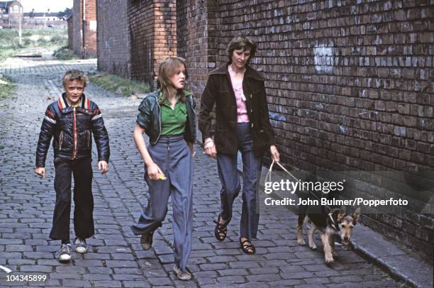 Family walking the dog on a street in Manchester, England in 1976.