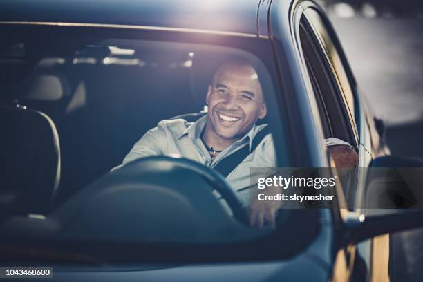 felice uomo d'affari afroamericano che va in viaggio in auto. - windshield foto e immagini stock