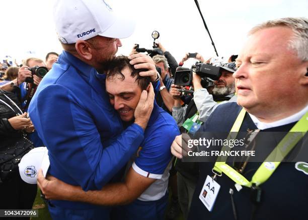 Europe's Italian golfer Francesco Molinari celebrates withEurope's Danish captain Thomas Bjorn after victory in during his singles match on the third...