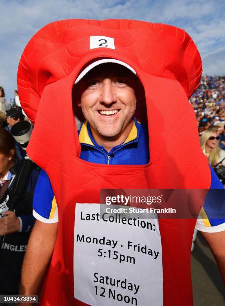 Ian Poulter of Europe celebrates winning The Ryder Cup after taking a Post Box outfitt off of a fan during singles matches of the 2018 Ryder Cup at...