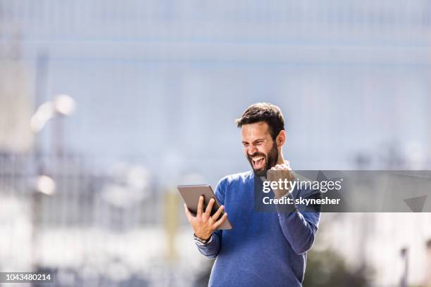 vrolijke zakenman met behulp van de touchpad en schreeuwen van blijdschap in de stad. - yes stockfoto's en -beelden