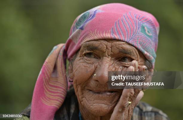 Elderly woman looks on as participants compete in the 14th edition of the Hero MTB Himalaya mountain bike race in the northern Indian state of...