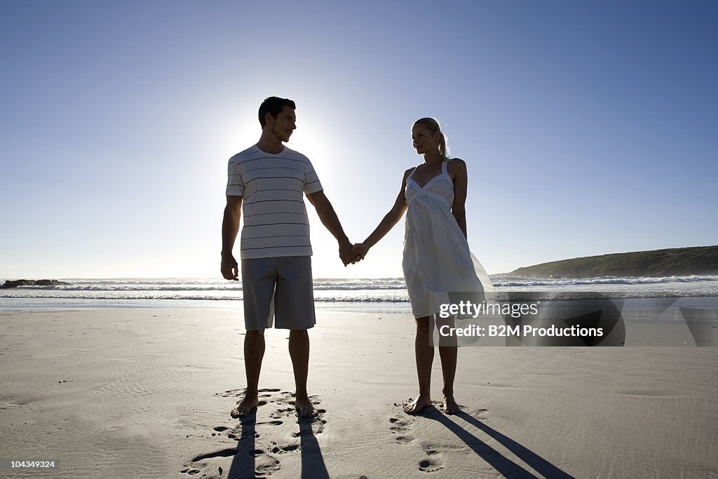 Couple hands to hands at beach