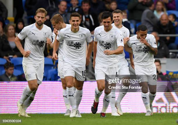 Johann Gudmundsson of Burnley celebrates with teammates after scoring his team's first goal during the Premier League match between Cardiff City and...