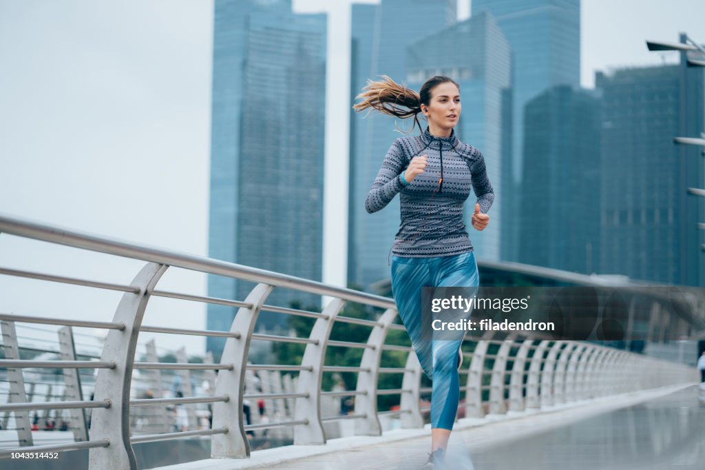 Sportswoman running on bridge