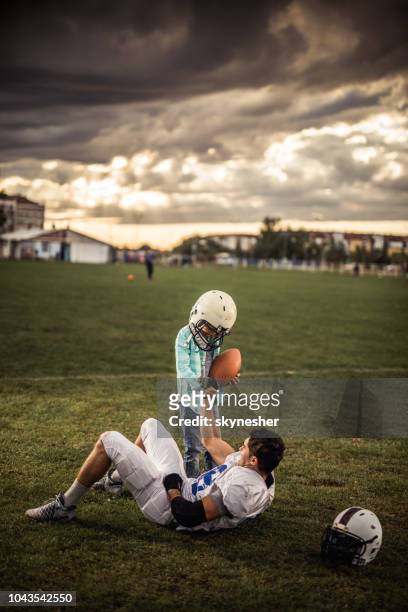 i will help you to get up! - father helping son wearing helmet stock pictures, royalty-free photos & images