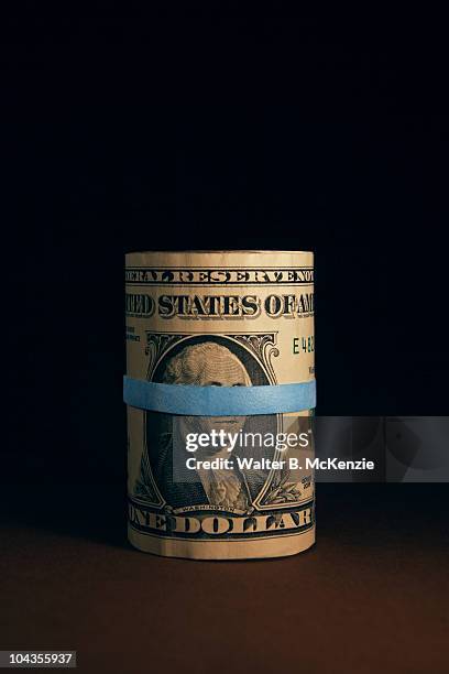 roll of us dollar bills with blue rubber band. - b roll stock pictures, royalty-free photos & images