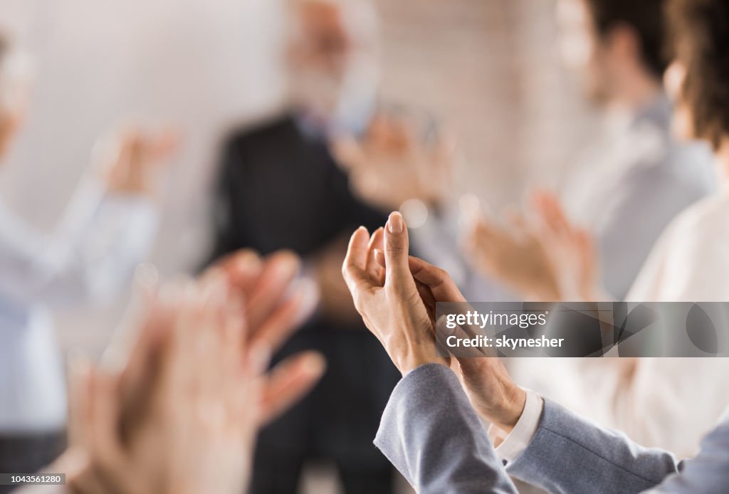 Group of unrecognizable business people applauding on a meeting.