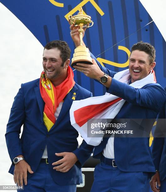 Europe's English golfer Justin Rose holds the trophy next to Europe's Spanish golfer Jon Rahm after Europe won the 42nd Ryder Cup at Le Golf National...