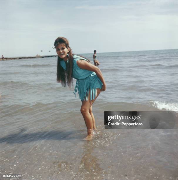 Italian actress Claudia Cardinale posed paddling in the sea on a beach during the 1960 Venice International Film Festival in Venice, Italy in...