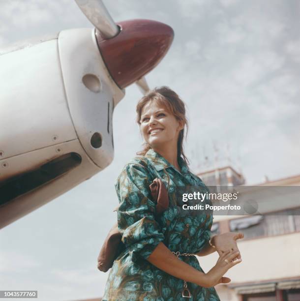 Italian actress Claudia Cardinale posed beside an aeroplane at Venice airport during the 1960 Venice International Film Festival in Venice, Italy in...