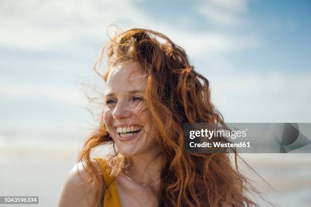 portrait of a redheaded woman, laughing happily on the beach - naturligt hår bildbanksfoton och bilder