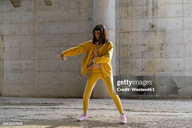 woman wearing yellow jeans clothes, dancing - giacca rosa foto e immagini stock