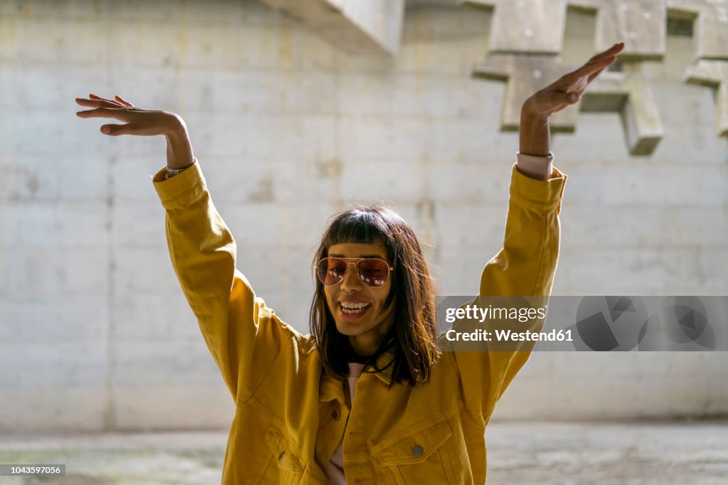 Young woman singing, raising arms