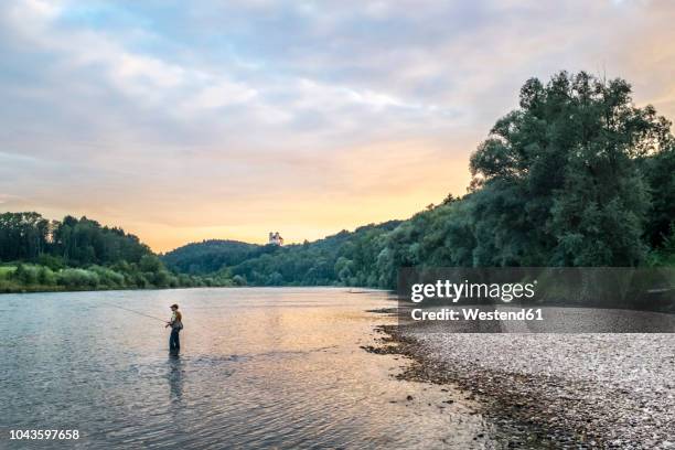 germany, upper bavaria, burghausen, salzach valley, fly fisherman at sunset - pêcheur photos et images de collection