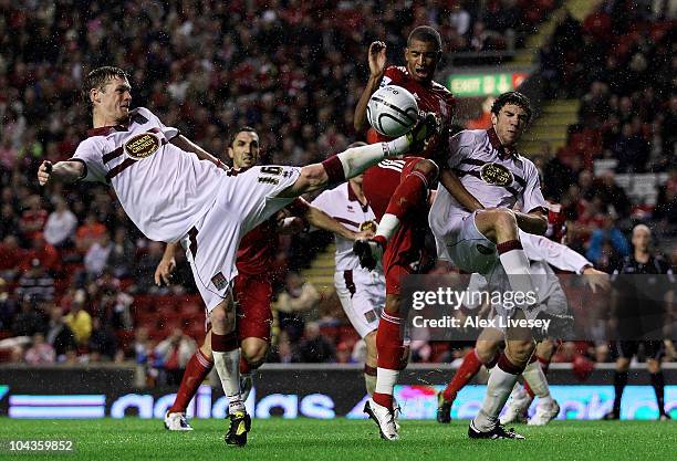 Billy McKay of Northampton Town challenges David Ngog of Liverpool during the Carling Cup Third Round game between Liverpool and Northampton Town at...