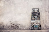 Retro old school design ghetto blaster boombox stereo radio cassette tape recorders tower from circa 1980s front concrete wall background. Vintage style filtered photo