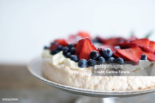 christmas pavlova wreath with fresh berries on a glass cake stand - merengue stock pictures, royalty-free photos & images