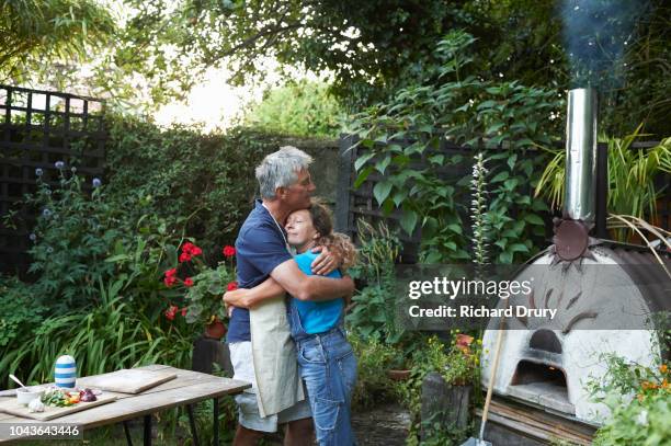 mature couple embracing in their garden - middle aged couple cooking ストックフォトと画像