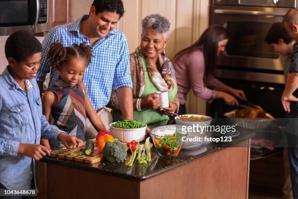 diverse family in home kitchen cooking thanksgiving dinner. - holiday healthy eating stock pictures, royalty-free photos & images