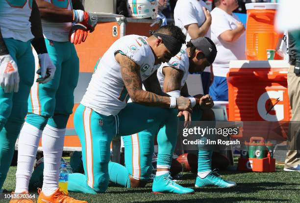 Kenny Stills and Albert Wilson of the Miami Dolphins kneel during the national anthem prior to their game against the New England Patriots at...