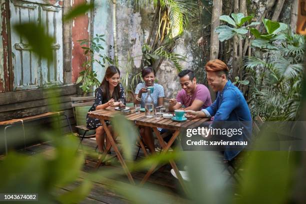 gruppo di quattro amici multietnici al bar - malese foto e immagini stock