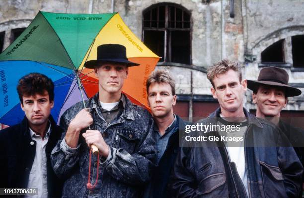 Portrait of Midnight Oil with Greenpeace 'Acid Rain' umbrella, Ghent, Belgium, 29th May 1988. L-R Rob Hirst, Peter Garrett, Martin Rotsey, Bones...