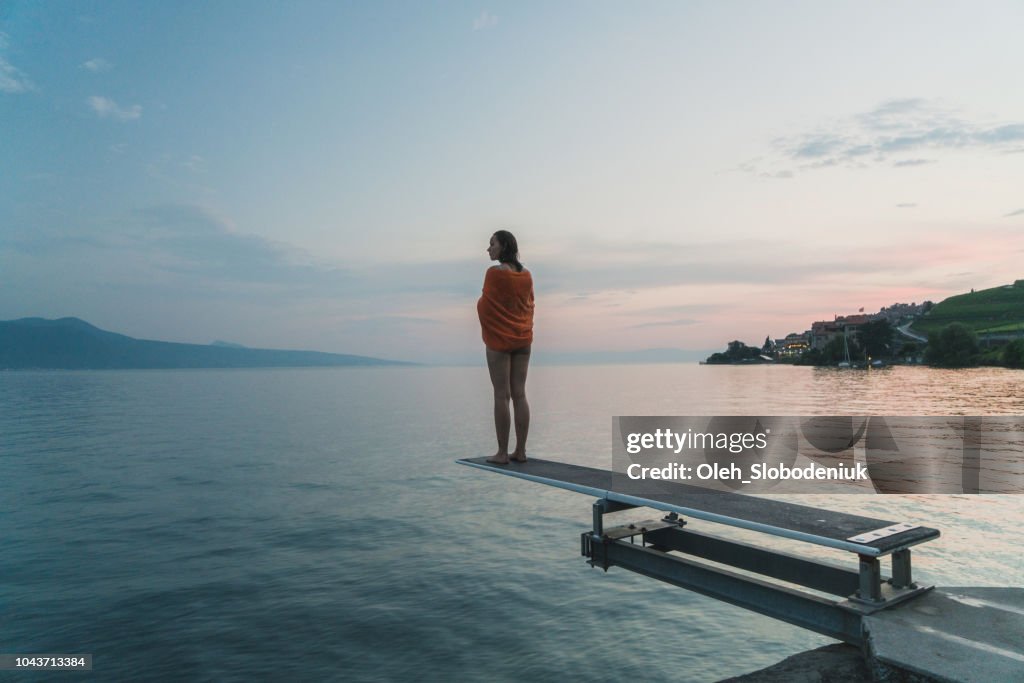 Woman standing on diving board on Geneva lake