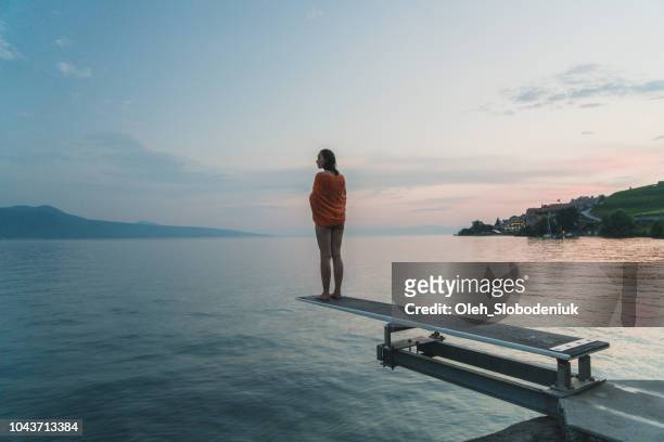 woman standing on diving board on geneva lake - geneva switzerland imagens e fotografias de stock