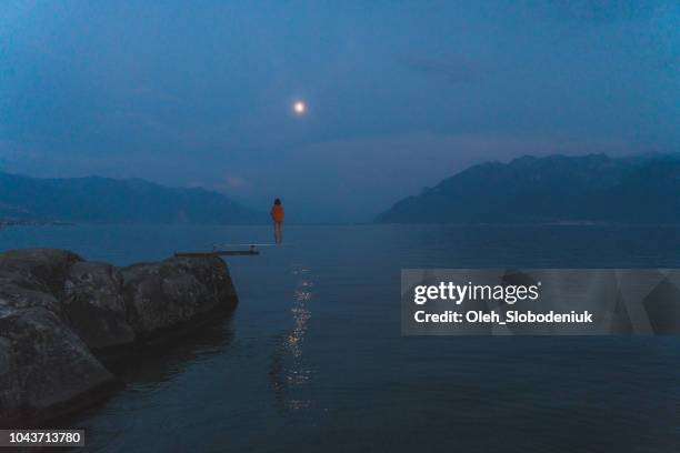 woman standing on diving board on geneva lake - woman diving board stock pictures, royalty-free photos & images