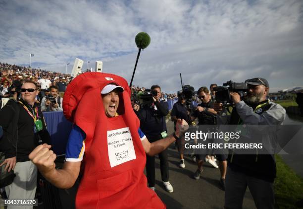 Europe's English golfer Ian Poulter wears a post box costume as he celebrates after Europe won the 42nd Ryder Cup at Le Golf National Course at...