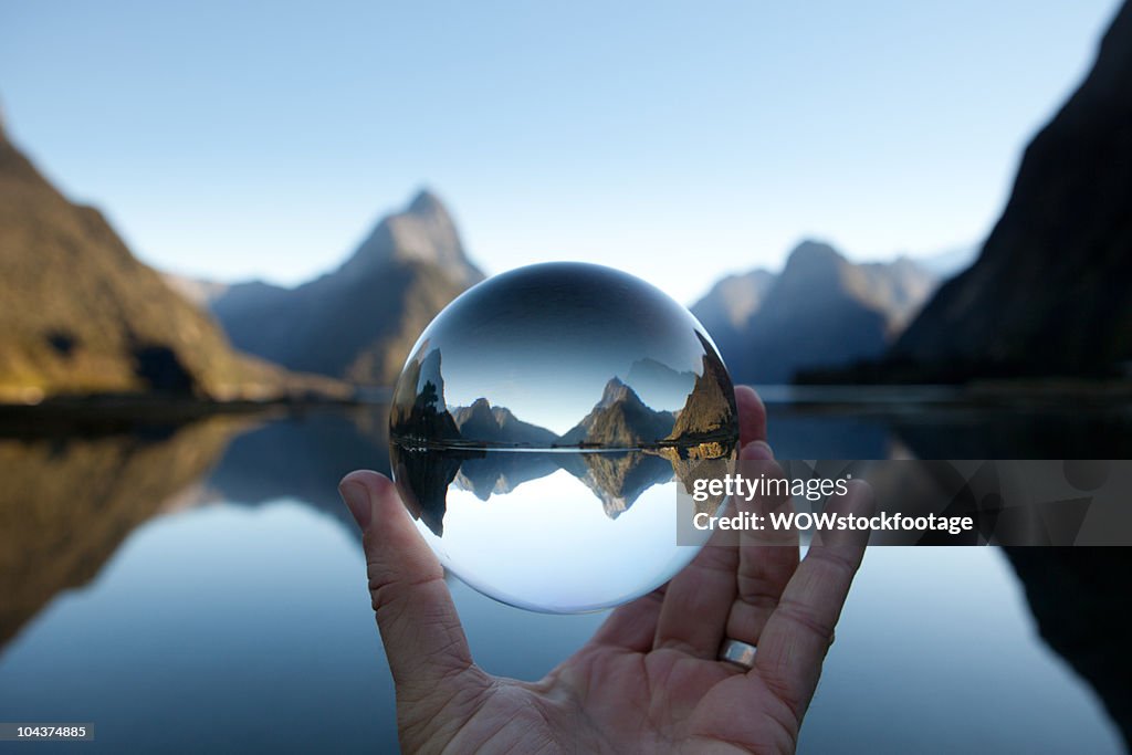 Man holding crystal ball in landscape