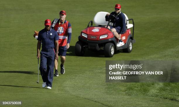 Golfer Tiger Woods walks during his singles match with Europe's Spanish golfer Jon Rahm on the third day of the 42nd Ryder Cup at Le Golf National...