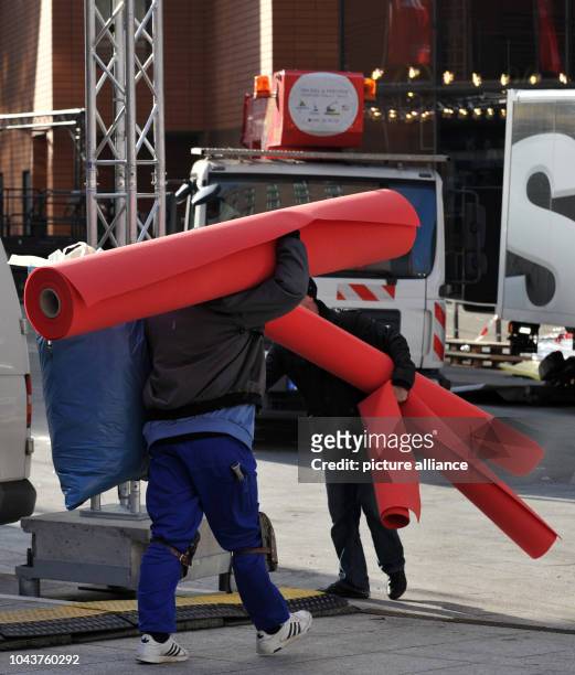 Workers carry the red carpet for the upcoming Berlin International Film Festival at Potsdamer Platz in Berlin, Germany, 06 February 2013....