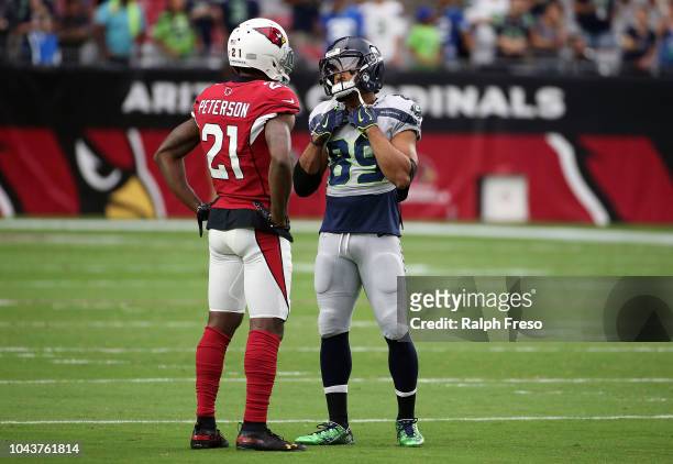 Defensive back Patrick Peterson of the Arizona Cardinals talks with wide receiver Doug Baldwin of the Seattle Seahawks before the game at State Farm...