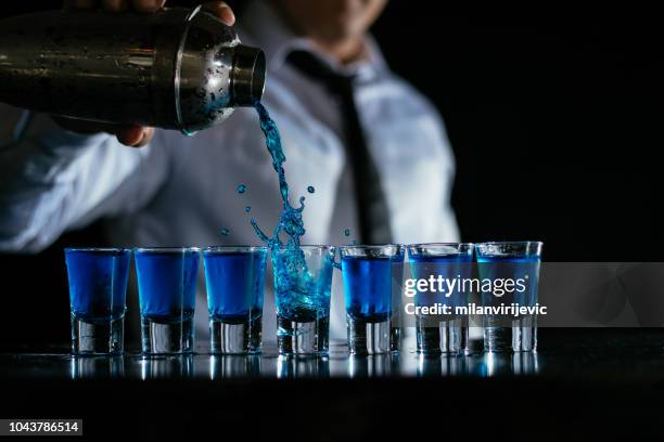 strömenden blauen cocktail aufnahmen - barman tequila stock-fotos und bilder