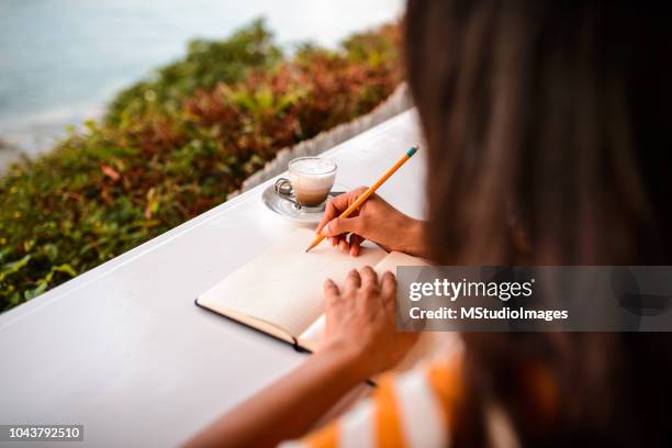 close up of a woman writing. - trip diary stock pictures, royalty-free photos & images