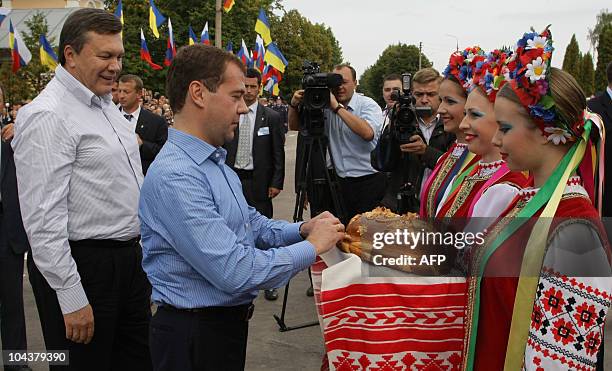 Russian President Dmitry Medvedev and his Ukrainian counterpart Viktor Yanukovich try traditional bread and salt during their meeting in Glukhov some...