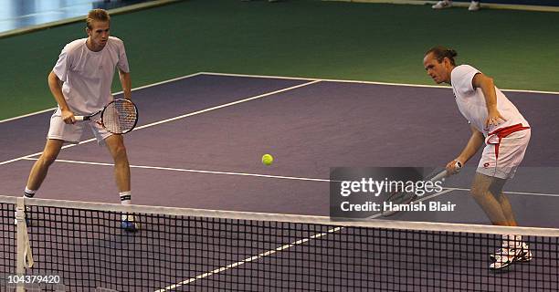 Xavier Malisse of Belgium plays a forehand with team mate Kristof Vliegen of Belgium looking on during their double match against Marcelo Melo and...